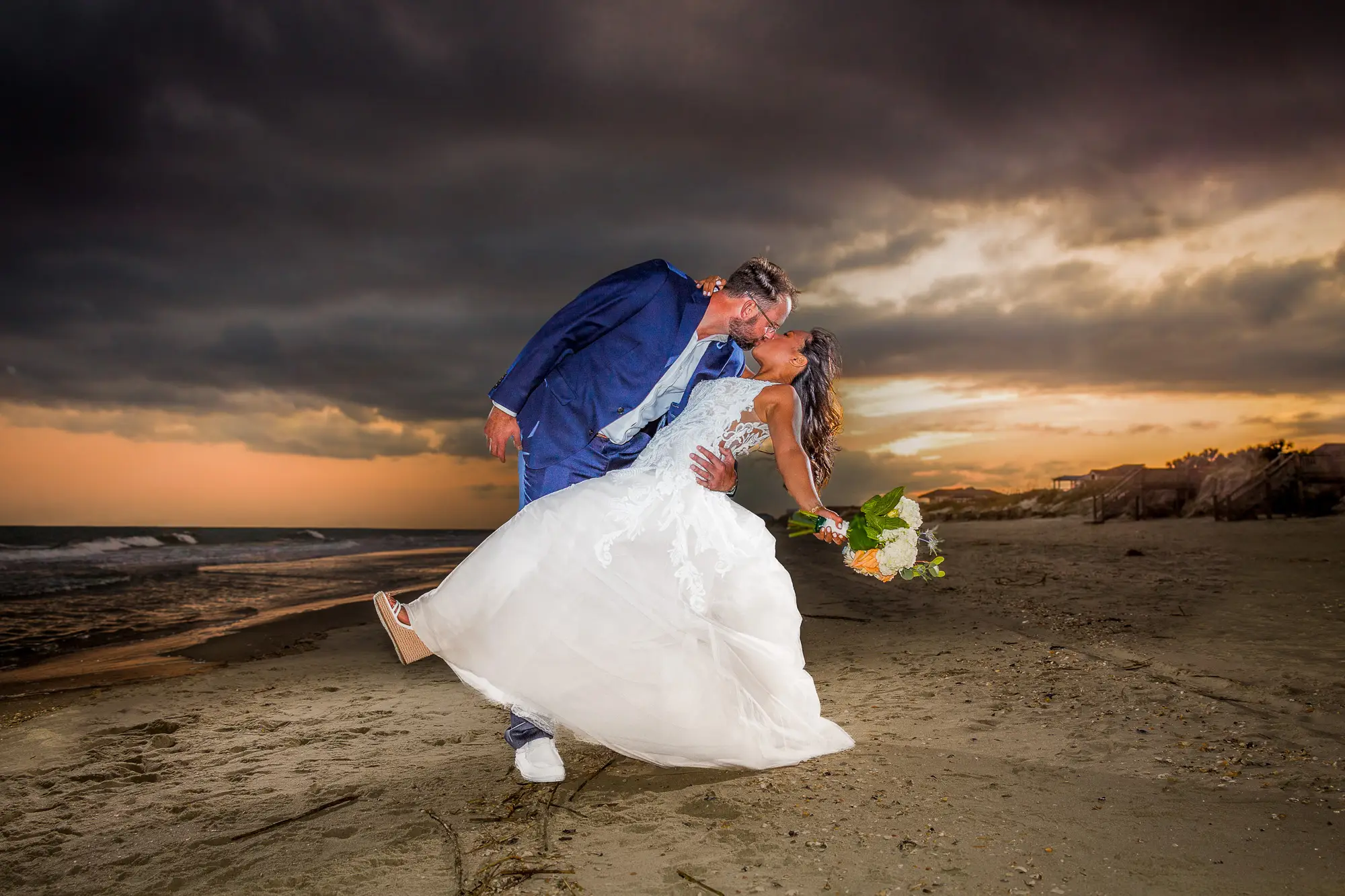 Bride and groom dip at sunset on Virginia Beach, captured by Virginia wedding photographer